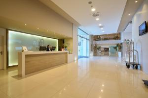 a woman sitting at a counter in a lobby at M.A. Hotel Sevilla Congresos in Seville +48 photos