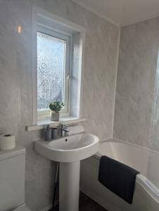 a bathroom with a sink and a window and a bath tub at 3 bed modern close to Nissan in Sunderland