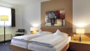 ein Schlafzimmer mit einem großen weißen Bett mit zwei Lampen in der Unterkunft Schlosshotel Ahaus in Ahaus