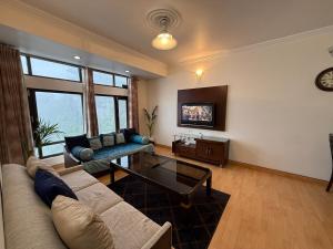 un soggiorno con un divano e un tavolo di CasaCosyMussoorie-MussoorieMallRoad-Landour-Aurora a Mussoorie