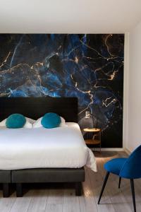 a bedroom with a bed with a painting on the wall at Logis Hotel-Restaurant Saint Romain in Anse