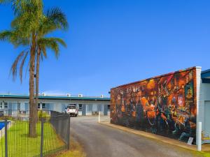 un mural en el lateral de un edificio con una palmera en Ship Inn Motel Yarram, en Yarram