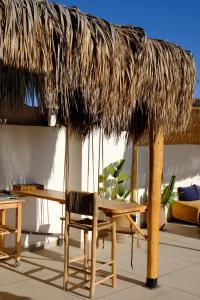 a table and a straw umbrella and a table and chair at Wavy Days in Tamraght Ouzdar