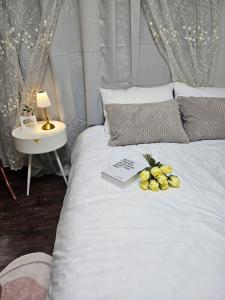 a white bed with a laptop and flowers on it at k조이스테이 in Pongsan-dong