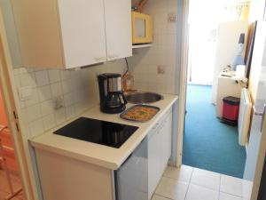 a small kitchen with a sink and a stove at Résidence Au Petit Chamois in Le Corbier