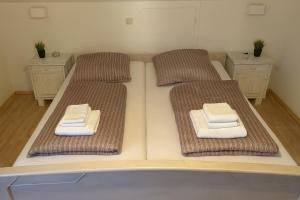 two beds in a room with towels on them at Tor zu Frankreich - Neuburg am Rhein in Neuburg