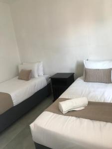 ウィントフークにあるCity Duplexの白いシーツが敷かれたベッドが2つある部屋