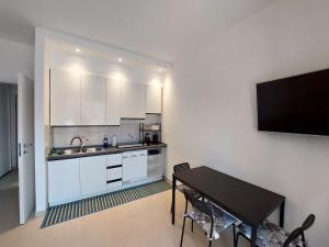 een keuken met een tafel en een televisie aan de muur bij Blue Iris - Varese - Laghi Svizzera in Varese