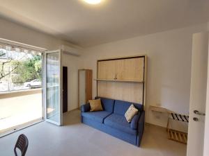 een woonkamer met een blauwe bank en een raam bij Blue Iris - Varese - Laghi Svizzera in Varese