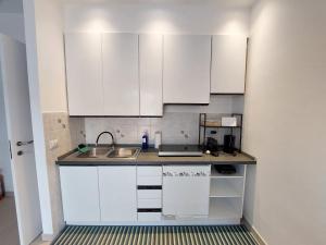 een keuken met witte kasten en een spoelbak bij Blue Iris - Varese - Laghi Svizzera in Varese