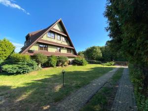 a house with a gambrel roof and a walkway at Kampinówka in Tułowice