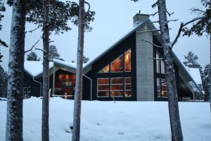 una casa en el bosque en la nieve en Årrenjarka Mountain Lodge, en Kvikkjokks Kapell