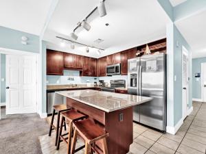 a kitchen with wooden cabinets and a stainless steel refrigerator at Laketown Wharf 331 in Panama City Beach
