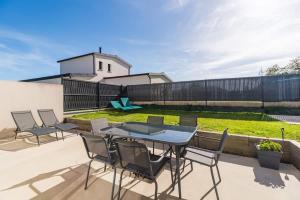 un patio con tavolo, sedie e cortile. di Ty Menez - Maison neuve proche commerces et plages a Pordic
