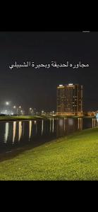 a city skyline at night with a body of water at Khobar Apartments in Al Khobar