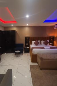 a hotel room with two beds and a couch at NO 95 SUITES VI in Lagos