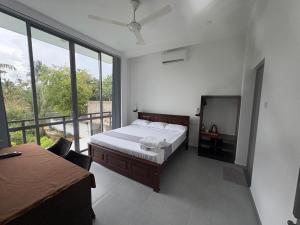 a bedroom with a bed and a television in it at Neilis Villa in Hikkaduwa