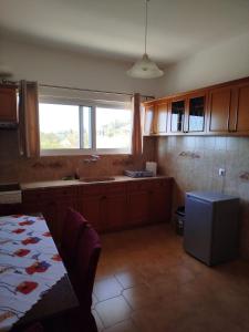 a kitchen with a table and a sink and a window at Nereids Apartments-Agavi in Petalidi +39 photos