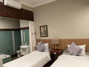 a room with two beds and a bathroom with a sink at Margot Guest House in Sanur +10 photos