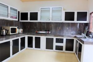 eine Küche mit schwarz-weißen Schränken und Geräten in der Unterkunft Glen Villa Holiday Home - Galle in Galle