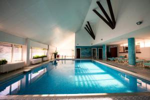 a large swimming pool in a large building at Complex Turistic Darina Sancraiu de Mures in Sîncraiu de Mureş