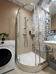 y baño con ducha y lavadora. en Olivias, en Qormi