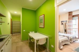 Habitación verde con mesa y cama en Appartamento a due passi dal mare. Civitanova M., en Civitanova Marche