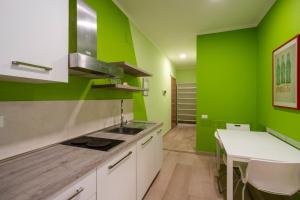 Una cocina con paredes verdes y encimera blanca. en Appartamento a due passi dal mare. Civitanova M., en Civitanova Marche