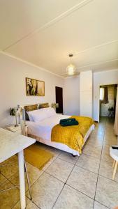 a bedroom with a large bed with a yellow blanket at O'Meara Overnight Rooms in Kimberley