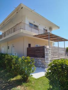 a large house with a balcony on top of it at Nereids Apartments-Agavi in Petalidi