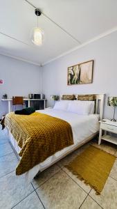 a bedroom with a large bed with a yellow blanket at O'Meara Overnight Rooms in Kimberley