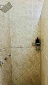 a bathroom with a shower with a tile wall at O'Meara Overnight Rooms in Kimberley +55 photos
