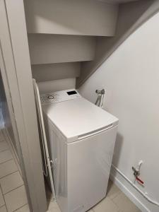 a small white washer and dryer in a room at Logis troglodyte cosy & vue sur la Loire in Souzay-Champigny