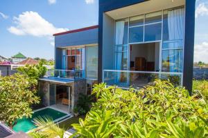una casa con pareti in vetro e una piscina di Villa Efes Bali a Seminyak