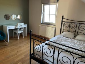 Un dormitorio con una cama y un escritorio con una silla. en Au Pré Bonheur, en Houyet