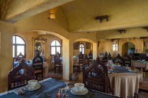 a dining room with tables and chairs and an elephant on the wall at Ksar Ouled Debbab  +77 photos