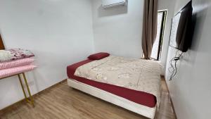 a small bedroom with a bed and a flat screen tv at Nafishah binti Abdul Ghapar in Tangkak +4 photos