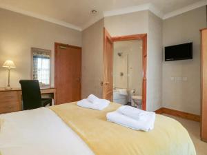 a bedroom with a large bed with two towels on it at Hambleton House in Castle Donington