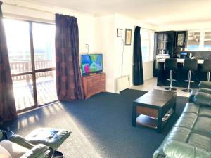 a living room with a couch and a television at Oceans Edge Three-bed rooms spacious house in Bluff in Bluff