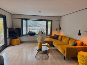 a living room with a couch and a tv at Gezellig chalet met 2 slaapkamers aan bosrand in Erm