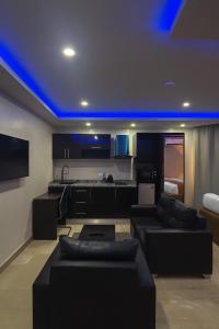 a living room with couches and a kitchen with blue lights at NO 95 SUITES VI in Lagos +21 photos