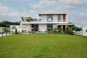 une maison avec une grande pelouse devant dans l'établissement SaffronStays Raaga, à Udaipur