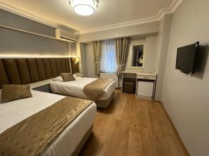 a hotel room with two beds and a television at Hotel Süreyya in Istanbul