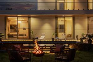 a backyard with a fire pit next to a house at SaffronStays Raaga - luxury 4BR villa with private pool, lawns, gazebos & sweeping Aravalli hill views in Udaipur