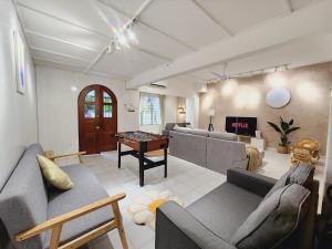 a living room with two couches and a table with a chess at NEW! Landed Home in Damansara Jaya for up to 15pax 1 mins to Atria ,1 Utama,TTDI in Petaling Jaya