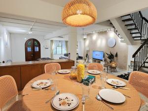 a dining room with a table with plates and glasses at NEW! Landed Home in Damansara Jaya for up to 15pax 1 mins to Atria ,1 Utama,TTDI in Petaling Jaya