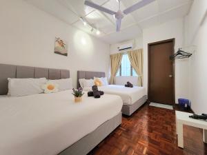two beds in a room with white walls and wood floors at NEW! Landed Home in Damansara Jaya for up to 15pax 1 mins to Atria ,1 Utama,TTDI in Petaling Jaya