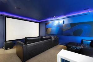 a theater room with black leather couches and a white screen at 2x Hottub, Pool, Minigolf, Theater,games, 20guests in San Antonio