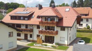 een huis met een rood dak en een balkon bij Haus Morgensonne in Höchenschwand