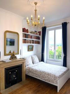 a bedroom with a bed and a mirror and a window at Appartement - Parking Gratuit - Métro in Villeurbanne